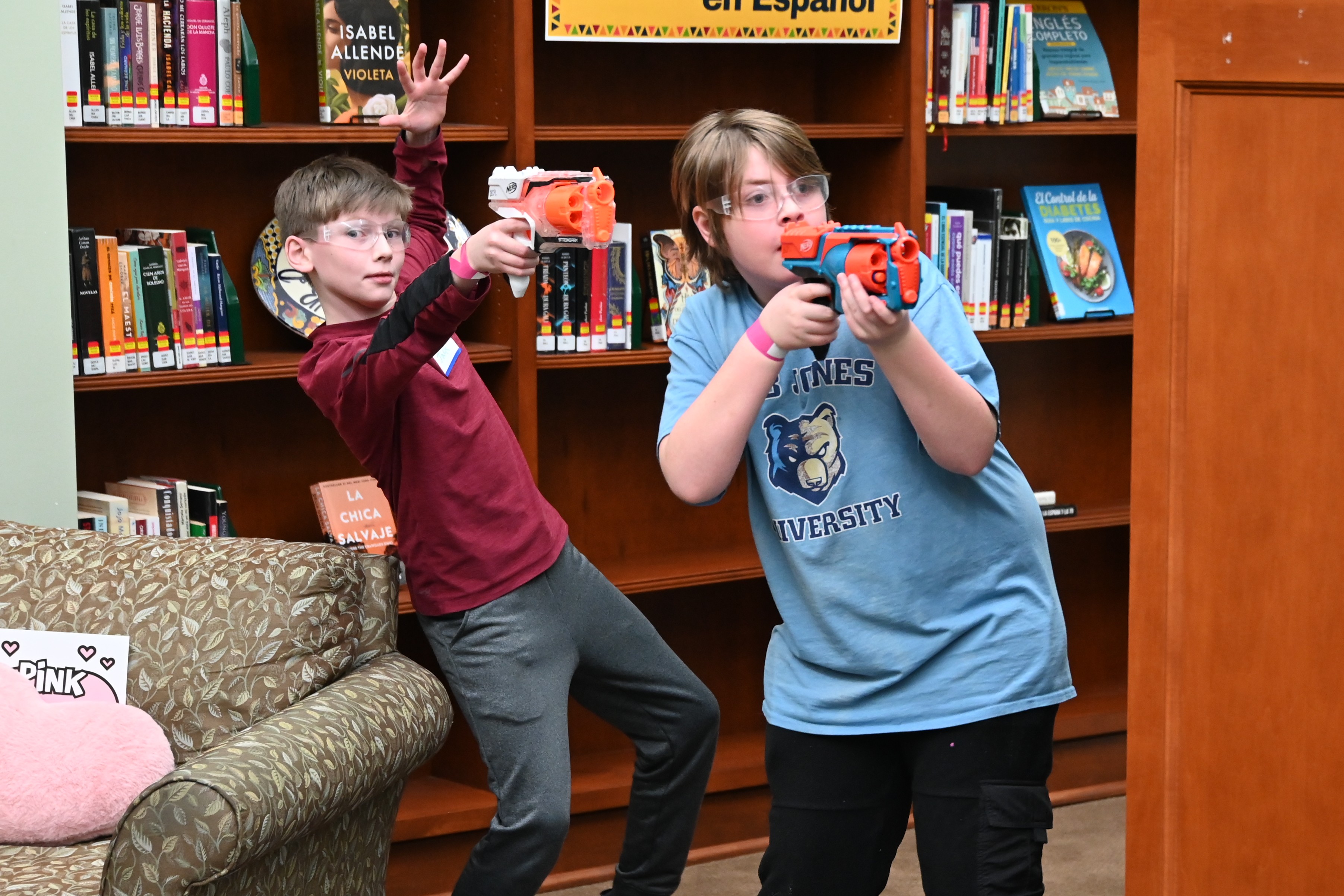 Two young adults appear out of the stacks to take aim at the YA Valentine Nerf Battle.