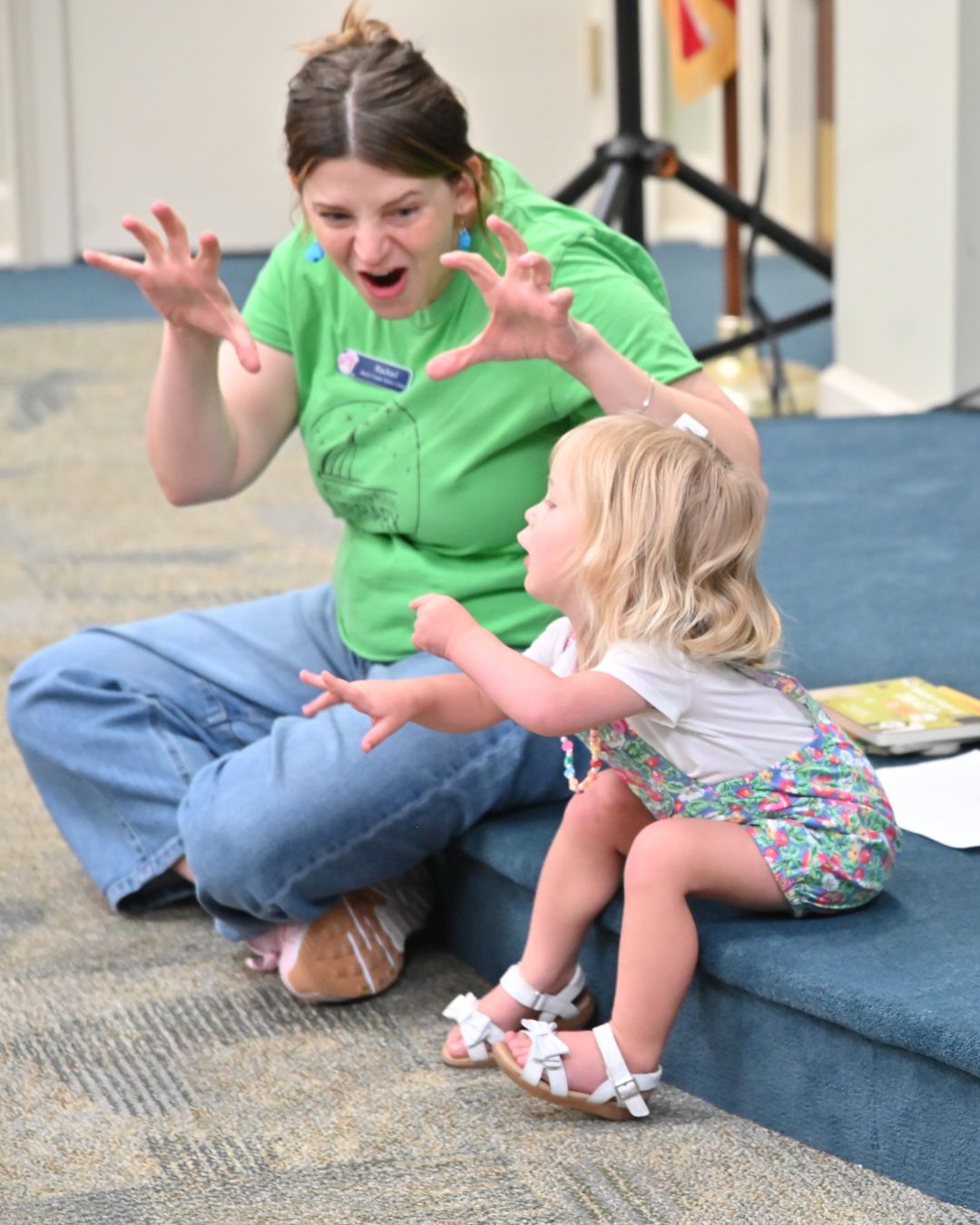 Adult and child during storytime. Both are making silly faces.